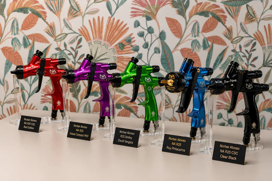 Exposición de cinco pistolas de pintura profesionales de la gama R25 NA de Crazy Business en una vitrina de taller, incluyendo los modelos Smiley David Vergara, Fire Pro, Vulcan y ediciones especiales de Norber Alonso.